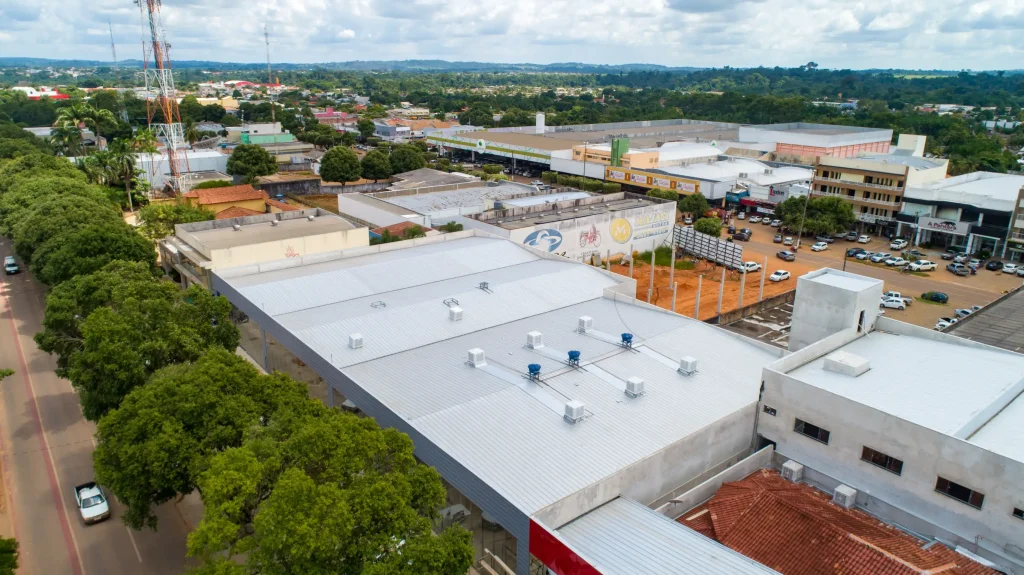 Aplicação de telhas térmicas em cobertura comercial no centro urbano.
